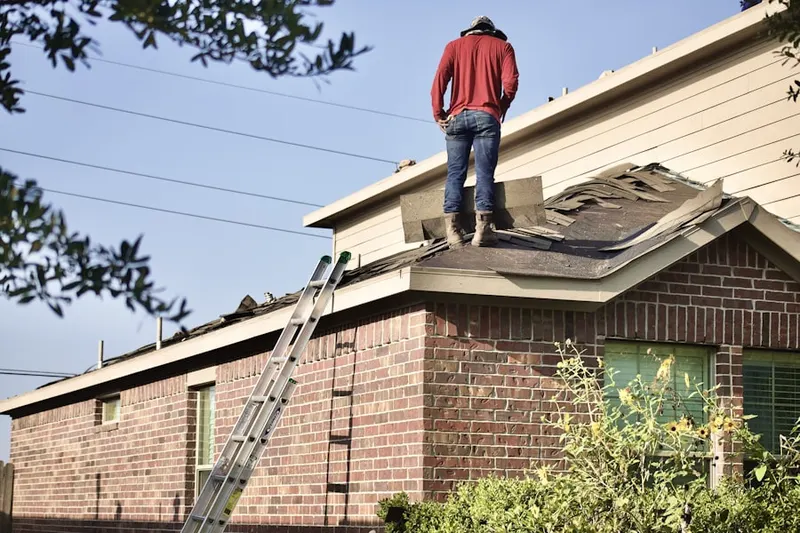 Professional roofer working on a residential roof in Brazos
